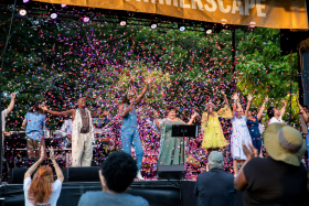Celebratory image of singers with confetti raining down. 