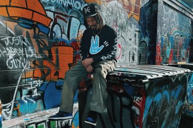 Mars Jackson sitting in front of graffiti wall