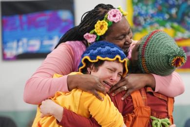 Three women hug each other
