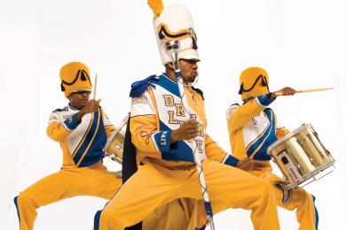 Photograph of marching band trio of musicians in HBCU-style yellow and blue uniforms