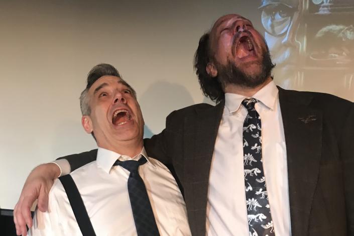 Two men next to each other, looking up and screaming