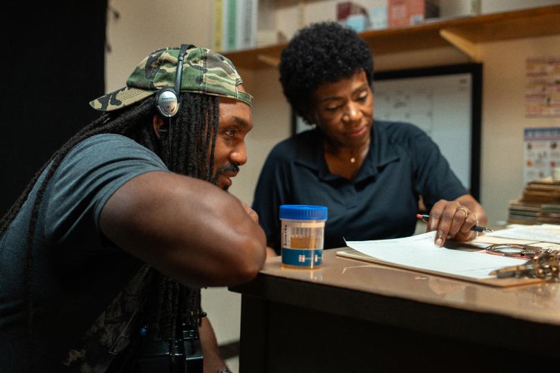 young man and a middle aged woman at a table reviewing a document